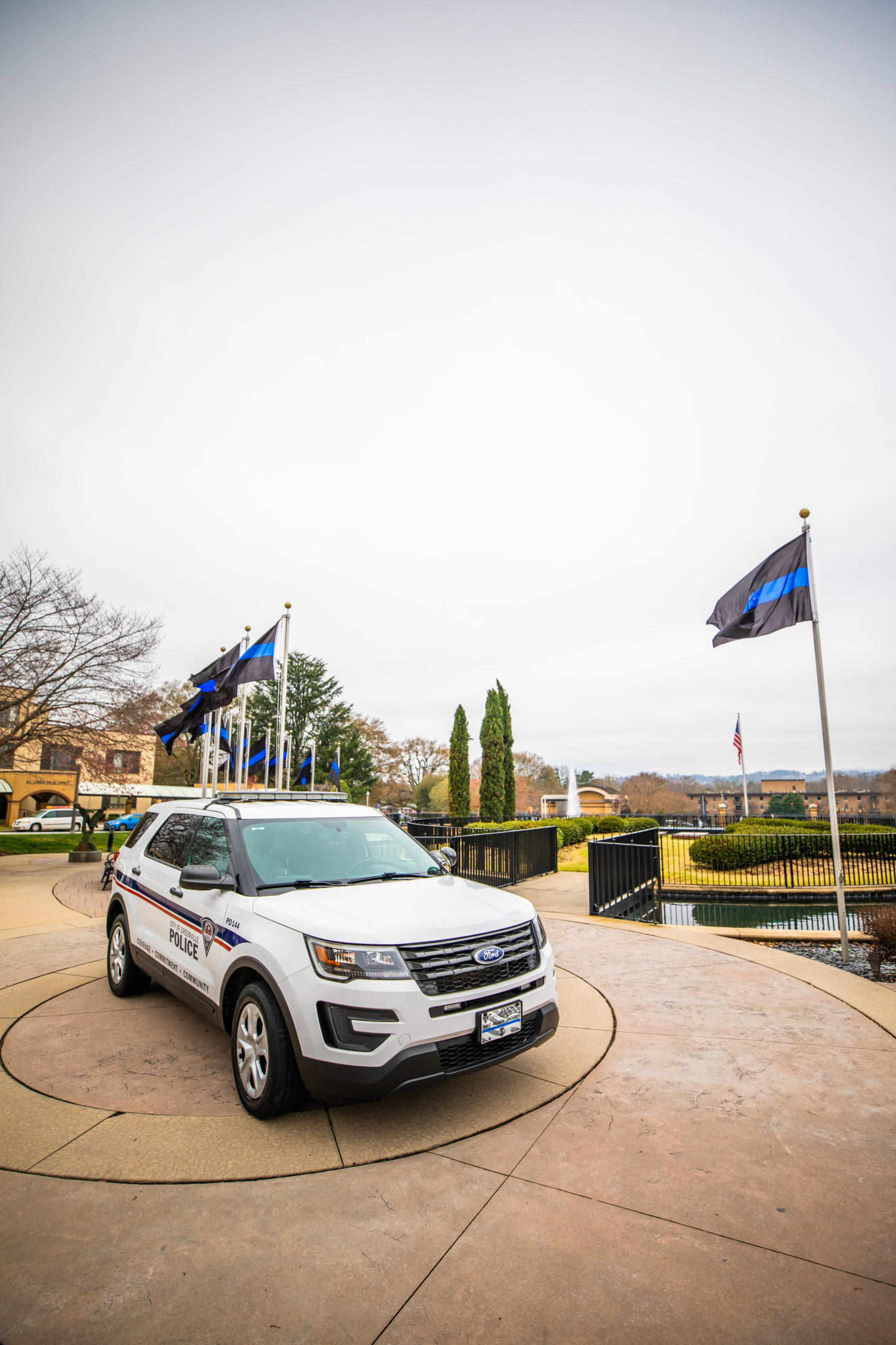 Police car and flags on front campus to honor fallen police officer Allen Jacobs, BJU, March 17, 2021. (Derek Eckenroth)
