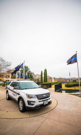 Police car and flags on front campus to honor fallen police officer Allen Jacobs, BJU, March 17, 2021. (Derek Eckenroth)